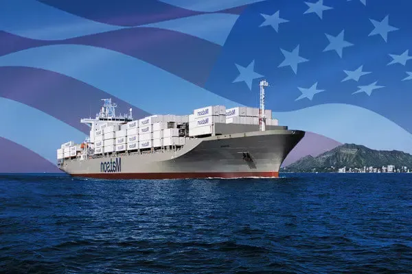 澳博体育app下载 ship loaded with containers arriving Honolulu with imposed American flag in the background.